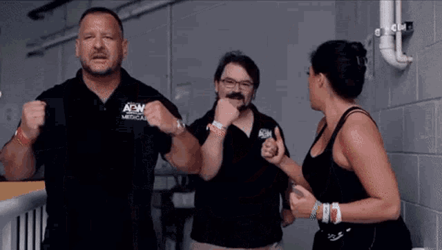 a man and a woman are standing next to each other and the man is wearing a shirt that says aew medical