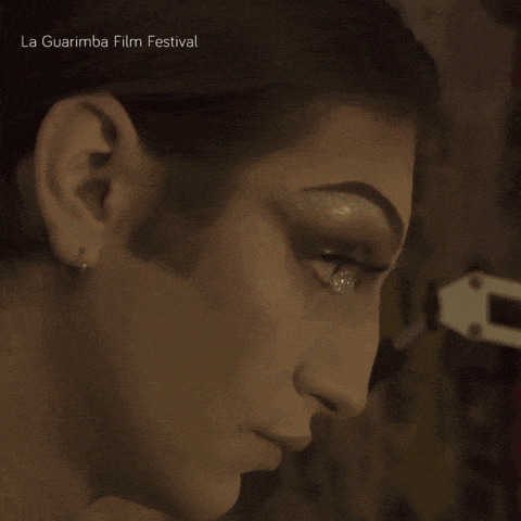 a close up of a woman 's face with la guarimba film festival written on the bottom right