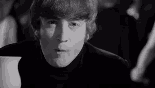 a black and white photo of a young man wearing a black turtleneck .