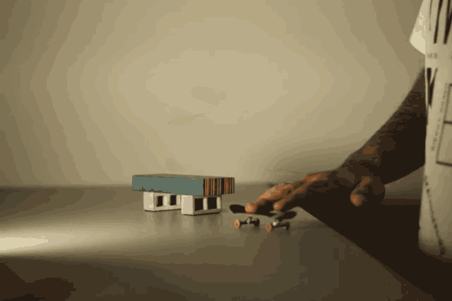 a person is playing with a toy house and a skateboard on a table