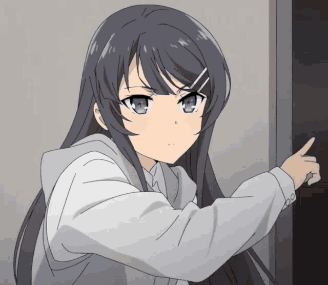a girl with long black hair and blue eyes is pointing