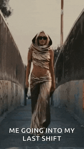 a woman in a gold dress is walking down a sidewalk .