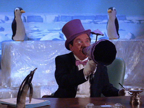 a man in a top hat and bow tie is blowing into a bucket
