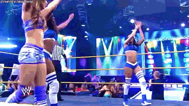 a group of female wrestlers are dancing in a ring .