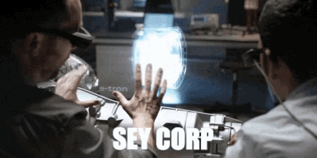 two men looking at a screen that says sey corp.