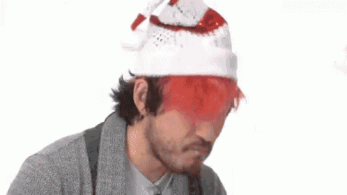 a man with red hair is wearing a santa hat .
