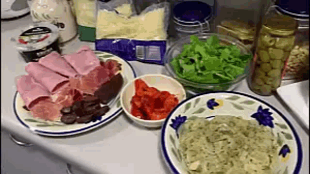 a table with plates and bowls of food including a bag of cheese