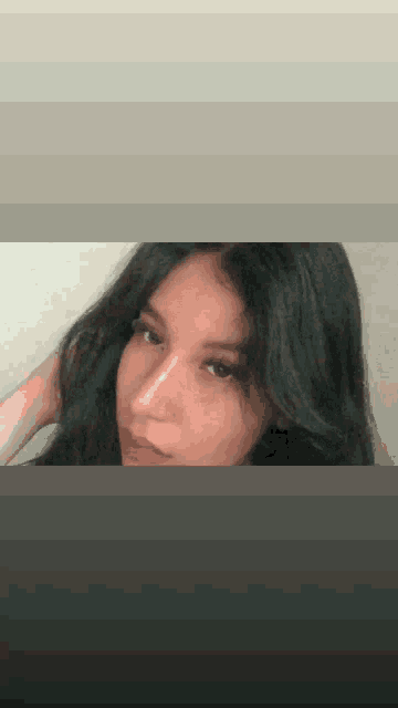 a close up of a woman 's face with long black hair