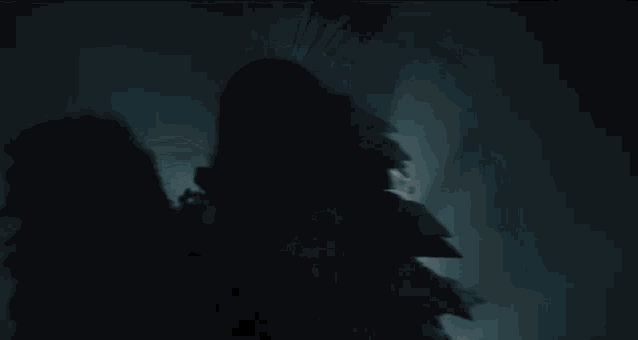 a woman with angel wings is playing a violin in a dark room