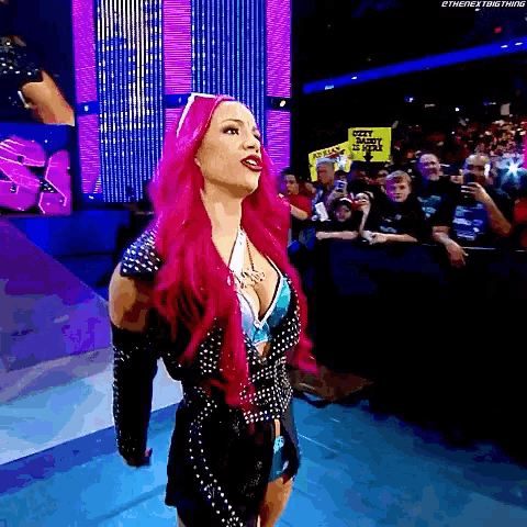 a woman with pink hair is standing in front of a crowd holding a sign that says soft justice