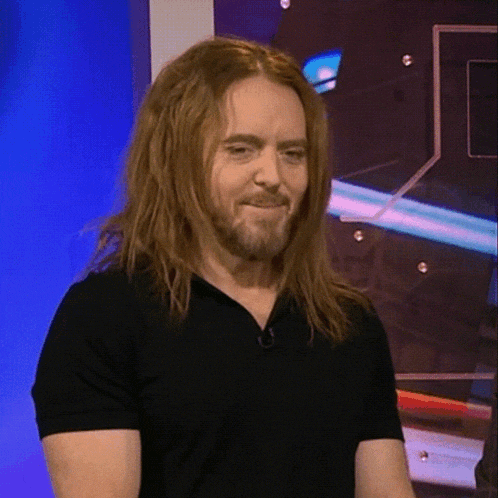 a man with long hair and a beard wearing a black shirt