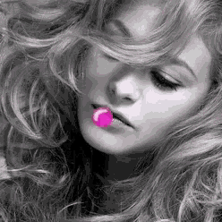 a black and white photo of a woman with a pink lollipop in her mouth .