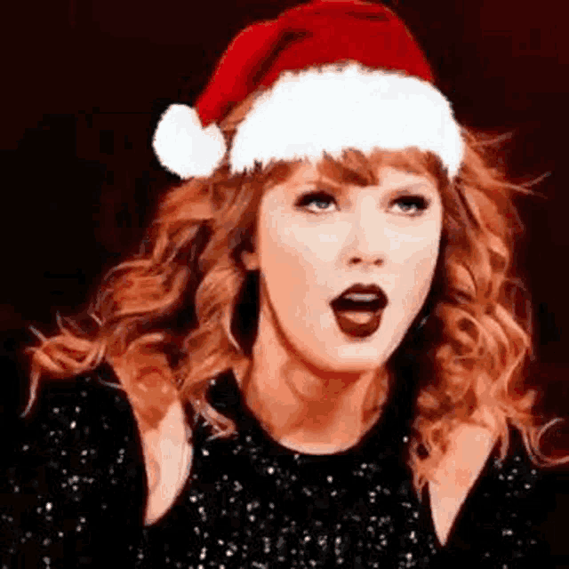 taylor swift is wearing a santa hat on her head .