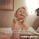 a little girl is talking on a cell phone while sitting on a bed .