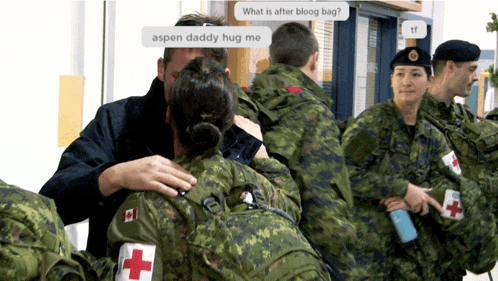 a group of soldiers are hugging each other and one of the soldiers has a red cross on her arm