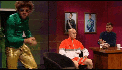 a man in an orange jacket with the number 13 on it is sitting in a chair