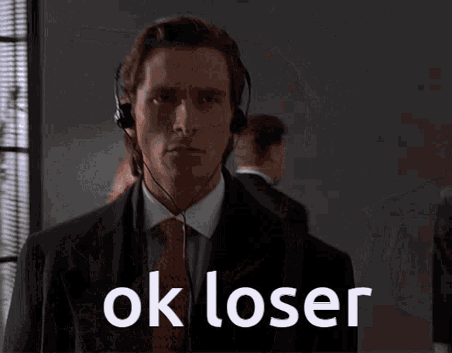 a man wearing headphones says ok loser in front of a group of people