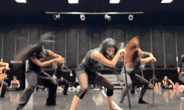 a group of women are dancing in a room with a sign that says ' a ' on it