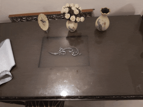 a table with a vase of flowers and a plate on it