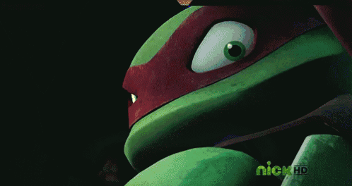 a close up of a teenage mutant ninja turtle 's face with red flames on it 's eyes .