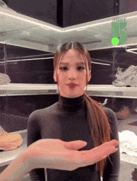 a woman in a black turtleneck is holding someone 's hand in front of a display of shoes