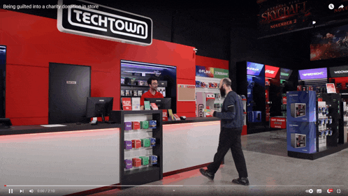 a video of a techtown store with a man walking past the counter