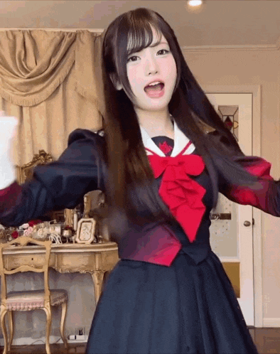 a girl in a school uniform with a red bow on her neck
