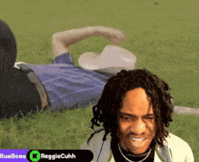 a man in a cowboy hat is laying in the grass with the name reggiecuhh in the corner