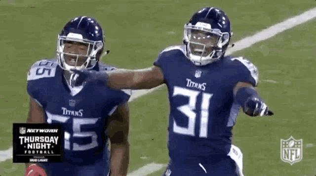 two titans football players are celebrating a touchdown on the field .