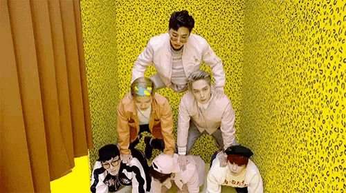 a group of young men are standing next to each other in a room with a leopard print wall .