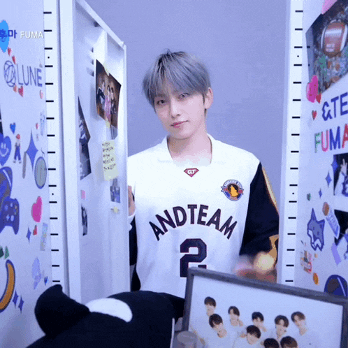 a man wearing a white and team jersey stands in a closet
