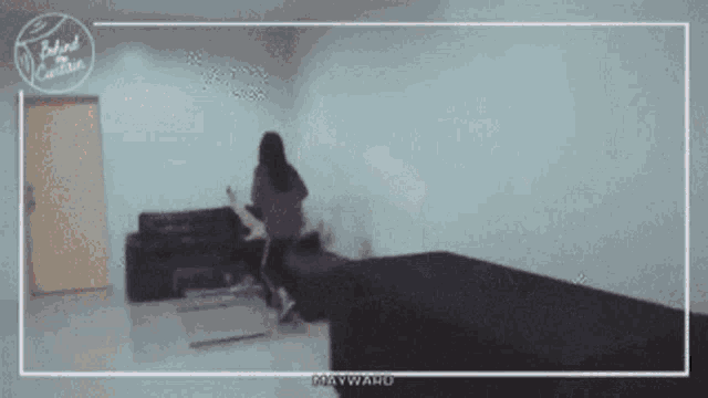 a blurry picture of a woman in a room with the words behind the camera written on the bottom