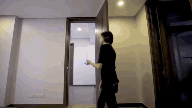 a man in a black shirt opens a door