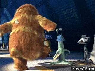a monster from the movie monsters inc is standing next to a green alien