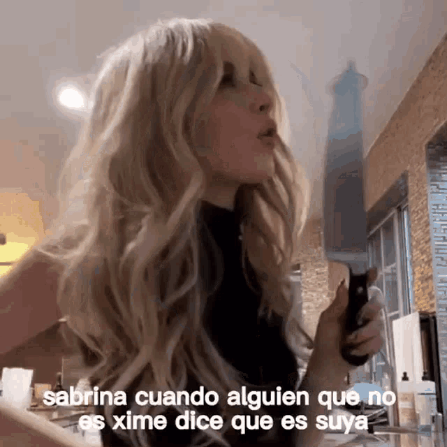 a woman with blonde hair is holding a large knife and says sabrina cuando alguen que no es xime dice que es suya