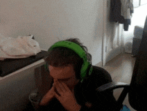 a man wearing green headphones is covering his nose