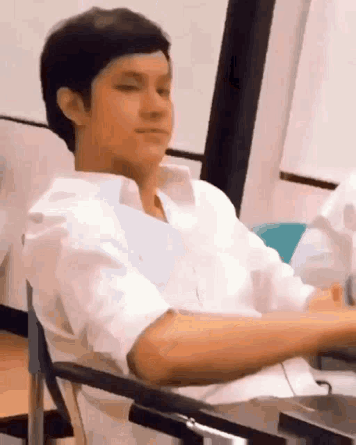 a young man is sitting in a chair with his eyes closed .