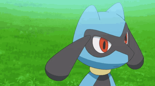 a blue and black cartoon character with red eyes is standing in the grass