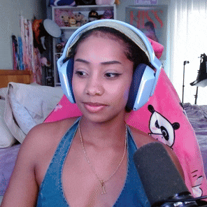 a woman wearing headphones holds a microphone in front of her face