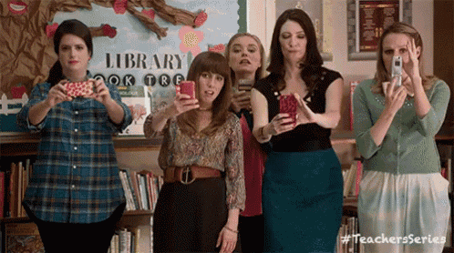 a group of women are taking a selfie in front of a library sign