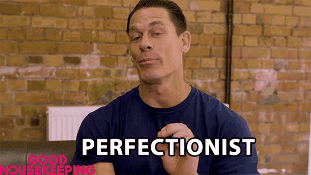 a man wearing a blue shirt with perfectionist written on it