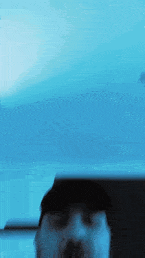 a blurry picture of a man 's face with a blue background