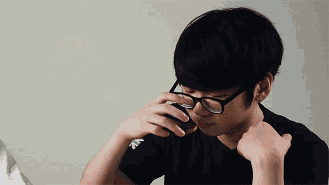 a man wearing glasses and a black shirt that says nz