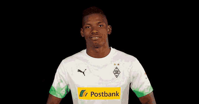 a young man wearing a white shirt with a postbank logo on his chest