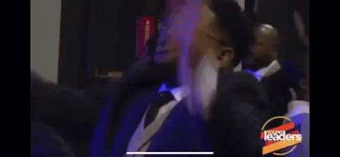 a man in a suit and tie is making a funny face with his mouth open .