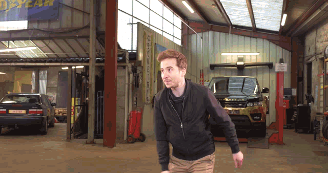 a man walking in a garage with a sign that says goodyear on it