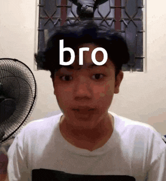 a young man is standing in front of a fan with the word bro on his face .