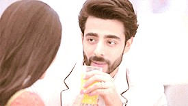 a man is drinking orange juice while looking at a woman