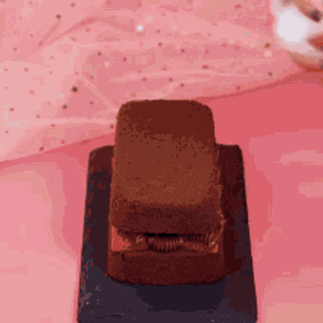 a chocolate cake with a strawberry filling is on a pink table .