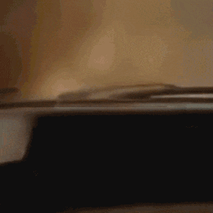 a blurred image of a car driving down a road with trees in the background